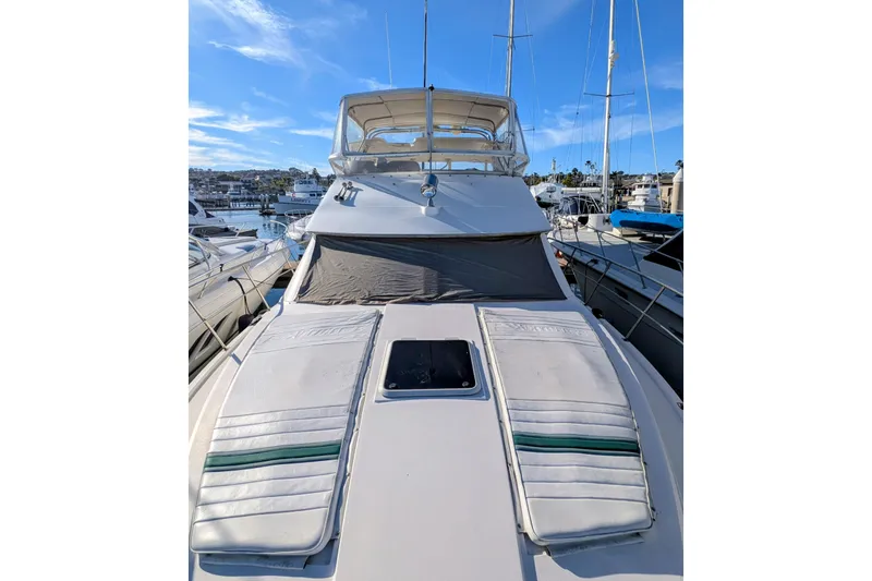 Slide: The Image of 1994 Cruisers Yachts 3850 Aft Cabin docked, featuring spacious deck and clear blue sky. - 12