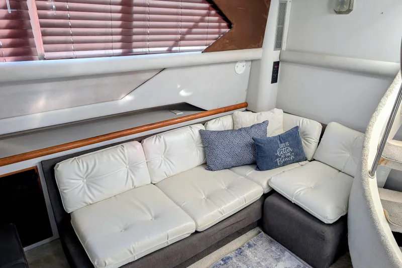 Slide: The Image of 1994 Cruisers Yachts 3850 Aft Cabin interior with white cushioned seating and decorative pillows. - 20