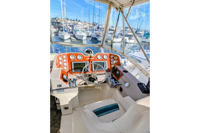 Slide: The Image of 1994 Cruisers Yachts 3850 Aft Cabin helm with marina view, featuring navigation instruments. - 5