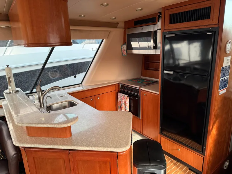 Slide: The Image of Interior of 2003 Meridian 490 Pilothouse yacht kitchen with wood cabinetry and modern appliances. - 10