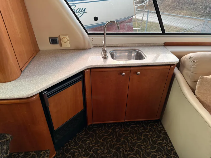 Slide: The Image of 2003 Meridian 490 Pilothouse interior with kitchenette, sink, and wooden cabinetry. - 17