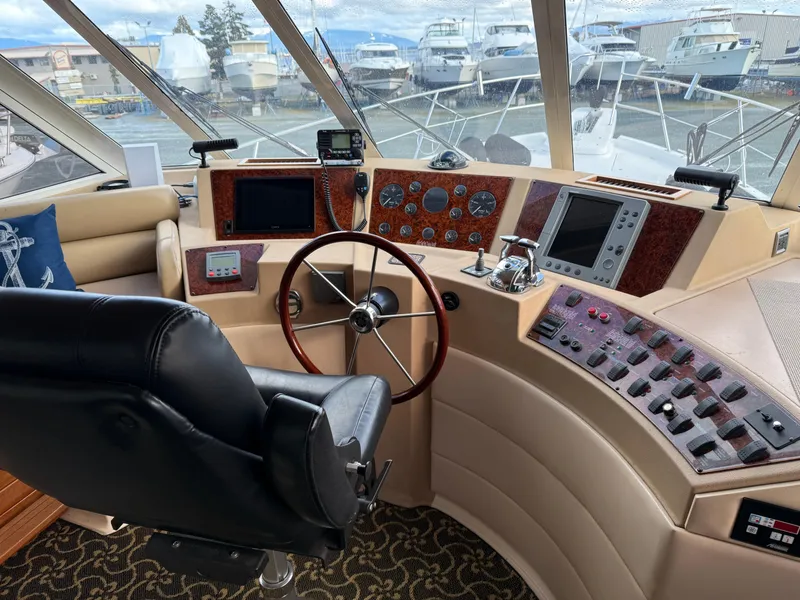 Slide: The Image of 2003 Meridian 490 Pilothouse interior with steering wheel, control panels, and navigation equipment. - 21