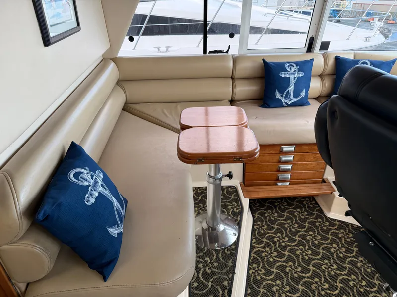Slide: The Image of Interior of 2003 Meridian 490 Pilothouse with beige seating and nautical-themed pillows. - 29