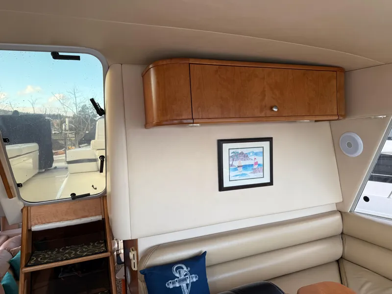 Slide: The Image of Interior of 2003 Meridian 490 Pilothouse with beige seating, wooden cabinet, and nautical decor. - 32