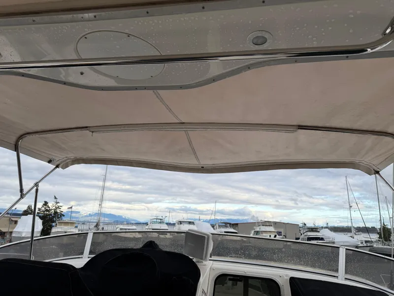 Slide: The Image of 2003 Meridian 490 Pilothouse boat with canopy, docked at marina under cloudy sky. - 52