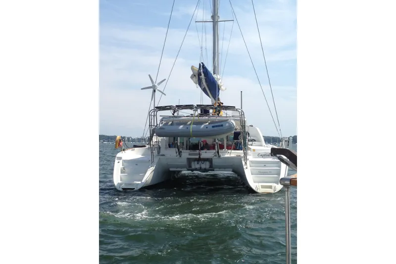 Slide: The Image of 2008 Lagoon 440 catamaran sailing on open water with dinghy and wind turbine. - 28