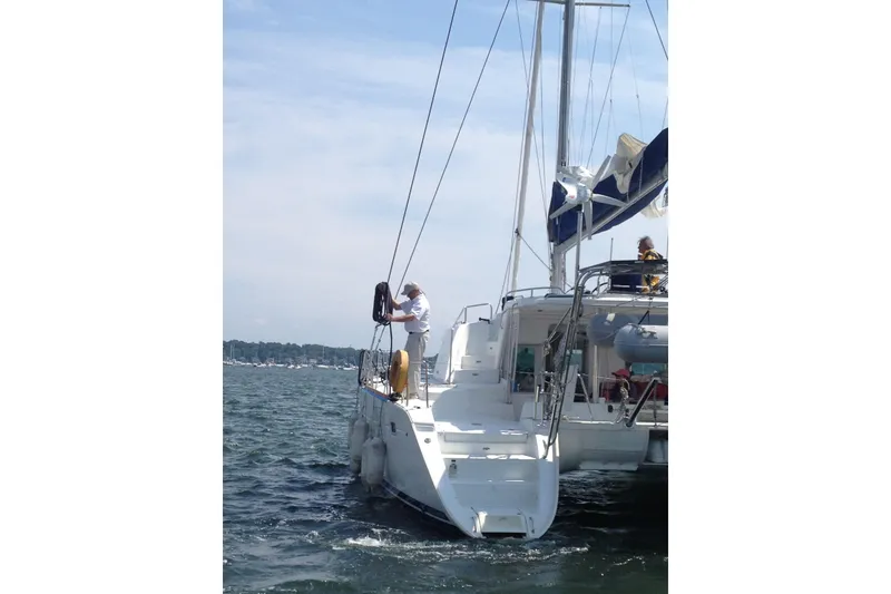 Slide: The Image of 2008 Lagoon 440 catamaran sailing on open water with crew on deck. - 29