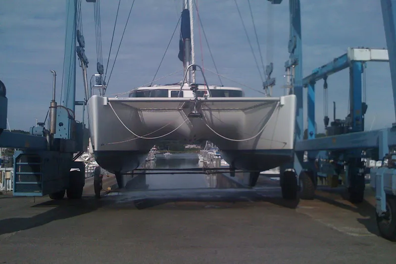 Slide: The Image of 2008 Lagoon 440 catamaran being lifted by a boat hoist at a marina. - 32