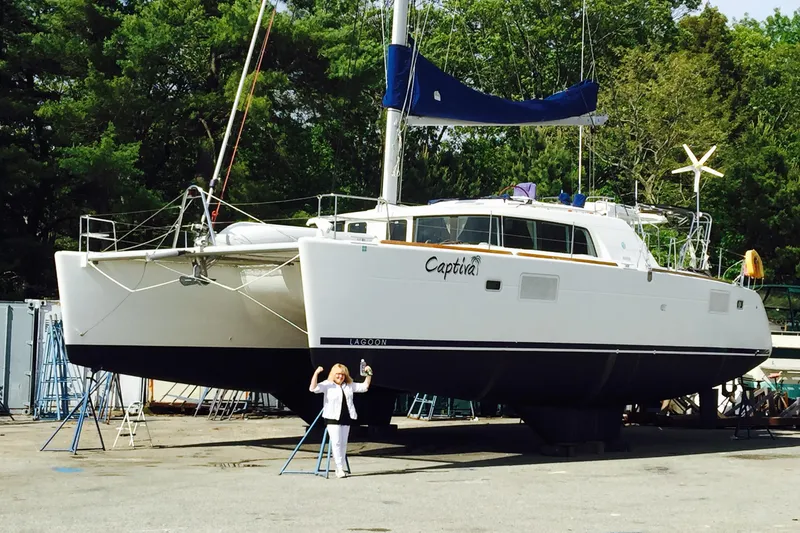 Slide: The Image of 2008 Lagoon 440 catamaran on land with a person standing in front. - 33