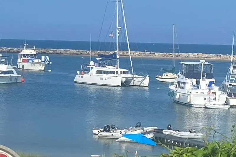Slide: The Image of Boats anchored in a harbor, featuring a 2008 Lagoon 440 catamaran. - 38