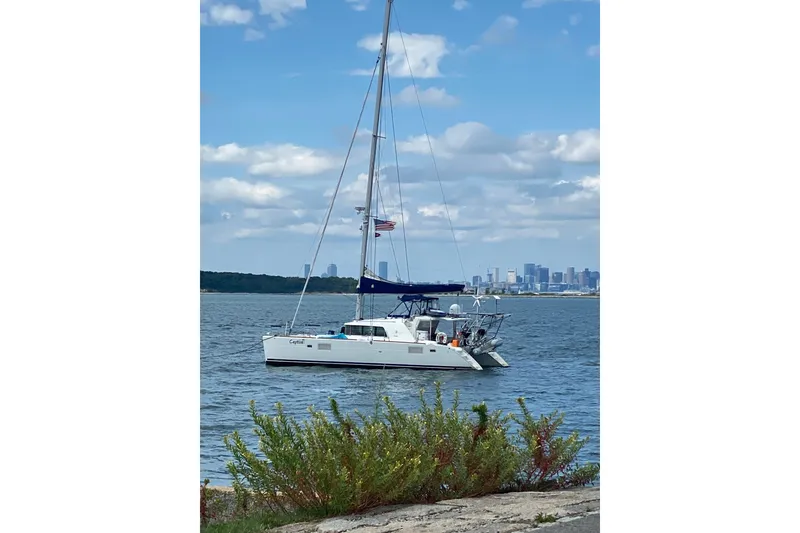 Slide: The Image of Sailing catamaran Lagoon 440 (2008) anchored near city skyline under blue sky. - 39