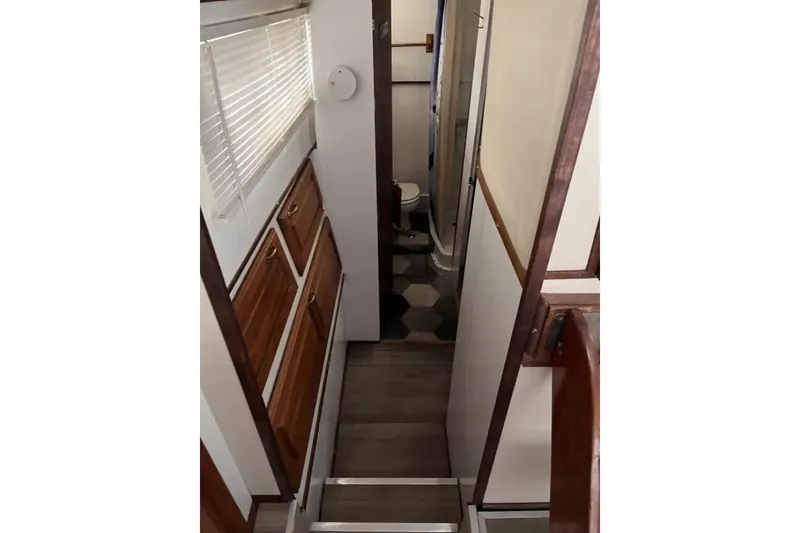 Slide: The Image of 1979 Chris-Craft 350 Catalina interior hallway with wooden cabinets and bathroom view. - 5