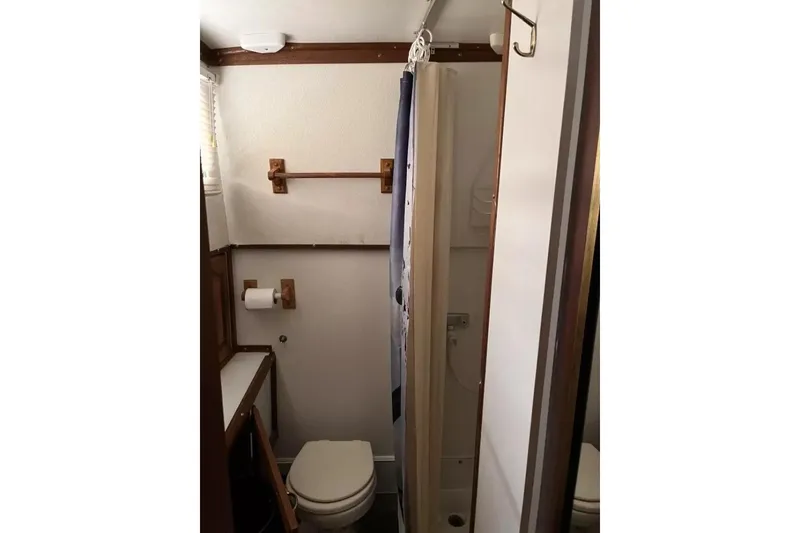 Slide: The Image of 1979 Chris-Craft 350 Catalina bathroom with shower, toilet, and wooden accents. - 6