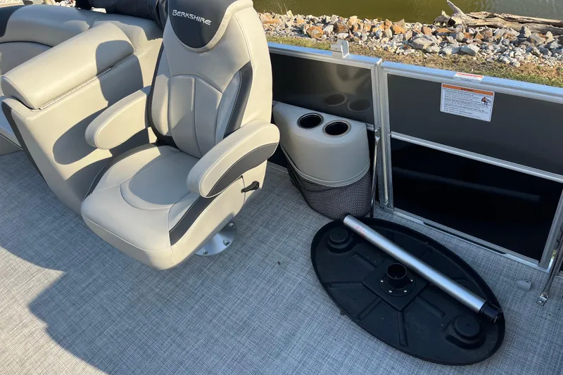 Slide: The Image of 2023 Berkshire 24RFX LE boat seat with armrests and cup holders, near water. - 11