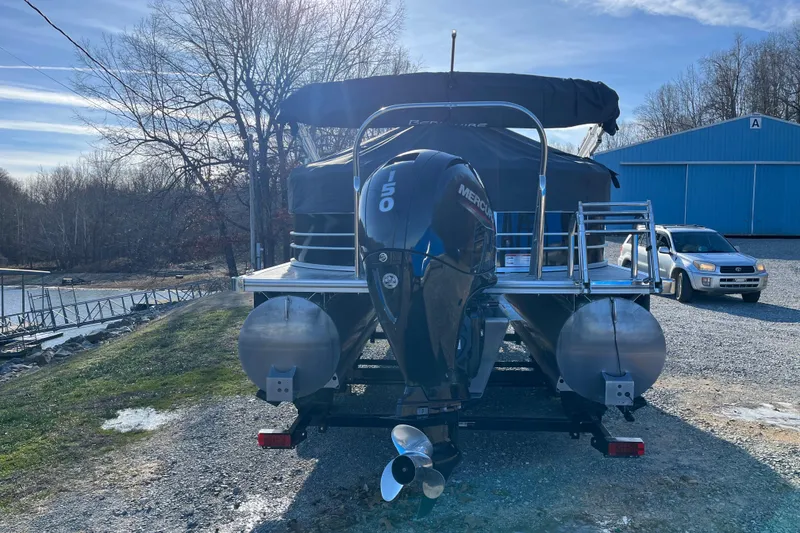 Slide: The Image of 2023 Berkshire 24RFX LE pontoon boat with Mercury 150 engine, parked near a lake. - 3
