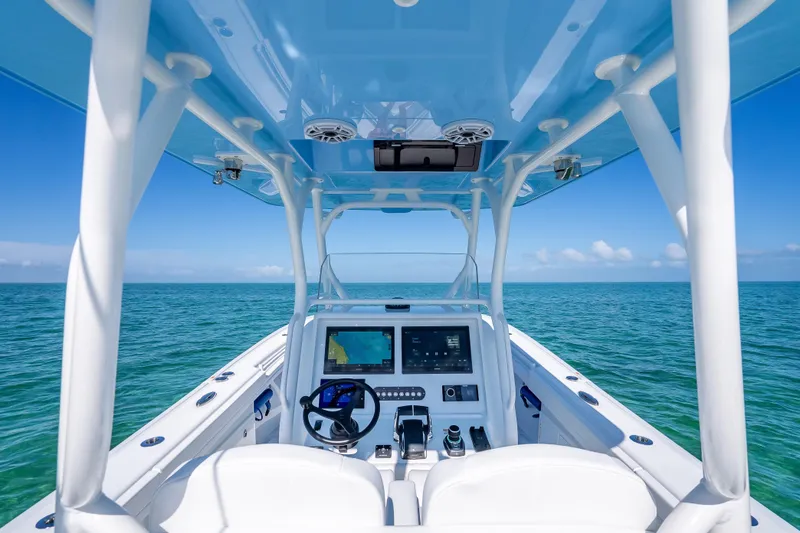 Slide: The Image of 2026 Yellowfin 32 Offshore boat dashboard with ocean view, featuring modern navigation equipment. - 16