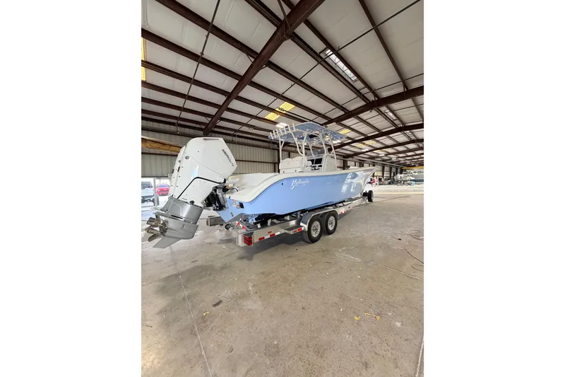 Slide: The Image of 2026 Yellowfin 32 Offshore boat on trailer in warehouse setting. - 2