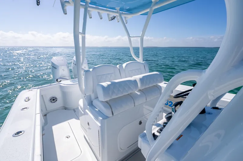 Slide: The Image of 2026 Yellowfin 32 Offshore boat interior with white seating, on a sunny ocean. - 21