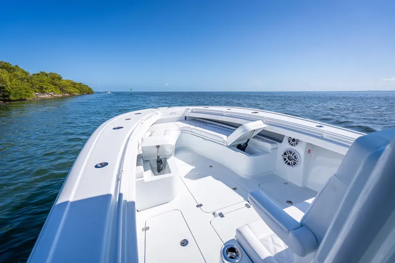 Slide: The Image of 2026 Yellowfin 32 Offshore boat on calm ocean near lush shoreline. - 33