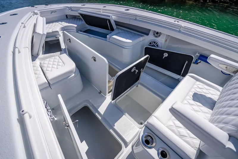 Slide: The Image of 2026 Yellowfin 32 Offshore boat interior with open storage compartments and cushioned seating. - 34