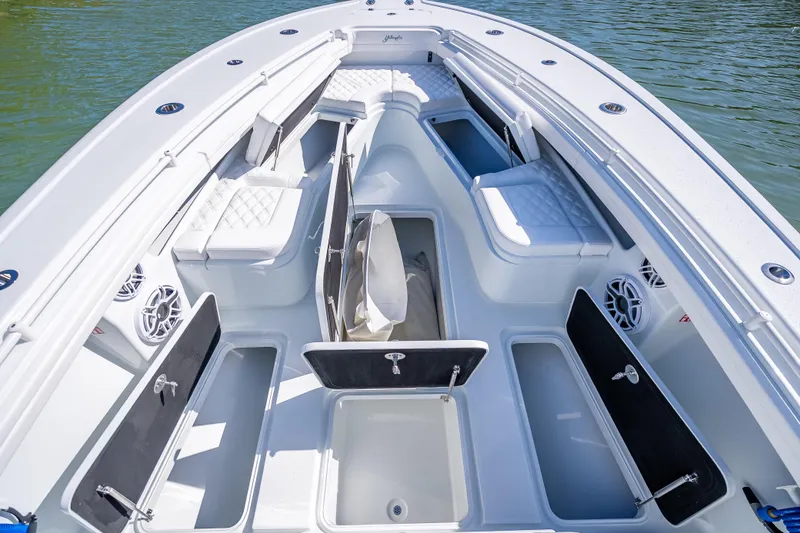 Slide: The Image of 2026 Yellowfin 32 Offshore boat interior with open storage compartments and cushioned seating. - 35