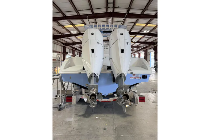 Slide: The Image of 2026 Yellowfin 32 Offshore boat with dual outboard engines in a warehouse setting. - 4