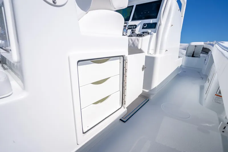Slide: The Image of 2026 Yellowfin 32 Offshore boat interior with storage drawers and control panel. - 45