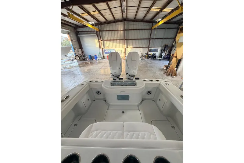 Slide: The Image of 2026 Yellowfin 32 Offshore boat interior in a spacious warehouse setting. - 8