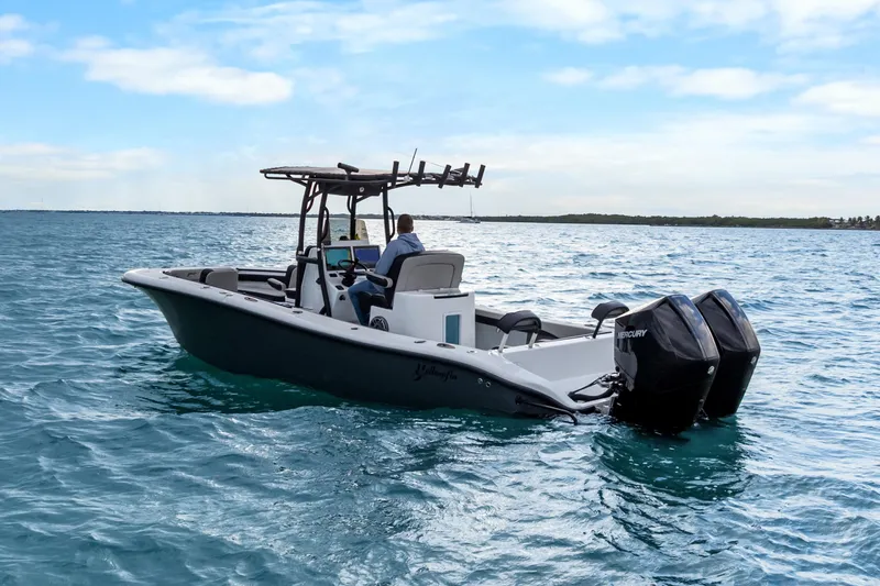 Slide: The Image of 2024 Yellowfin 26 Hybrid boat cruising on open water with dual Mercury engines. - 14