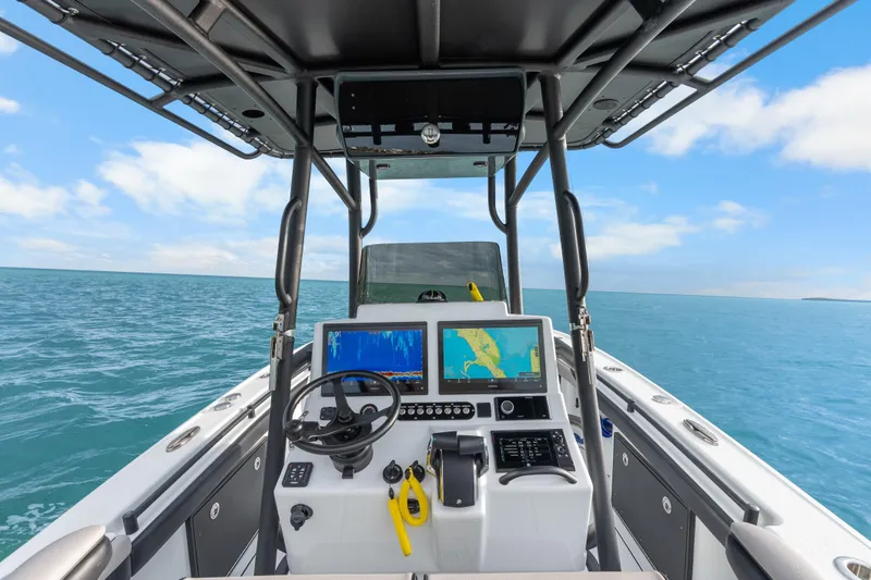 Slide: The Image of 2024 Yellowfin 26 Hybrid boat dashboard with navigation screens on open water. - 18
