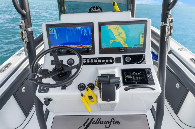 Slide: The Image of 2024 Yellowfin 26 Hybrid boat dashboard with navigation screens and steering wheel. - 19