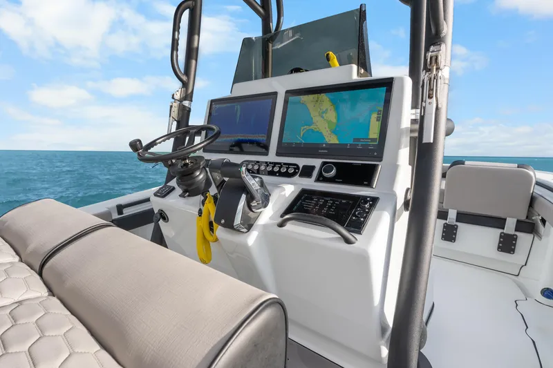 Slide: The Image of 2024 Yellowfin 26 Hybrid boat dashboard with navigation screens and steering wheel. - 22