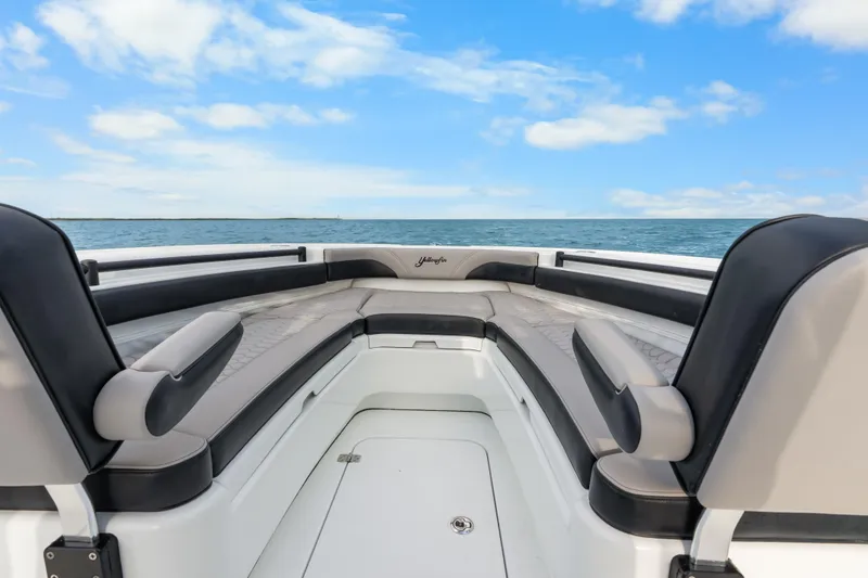 Slide: The Image of 2024 Yellowfin 26 Hybrid boat interior with cushioned seating, ocean view, and blue sky. - 23