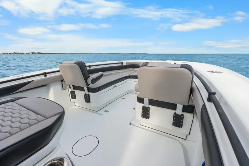 Slide: The Image of 2024 Yellowfin 26 Hybrid boat interior with cushioned seating, ocean view, and blue sky. - 24