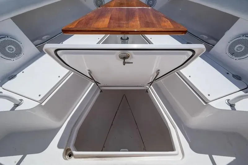 Slide: The Image of Open storage compartment on 2019 Everglades 435 Center Console boat with wooden table. - 15