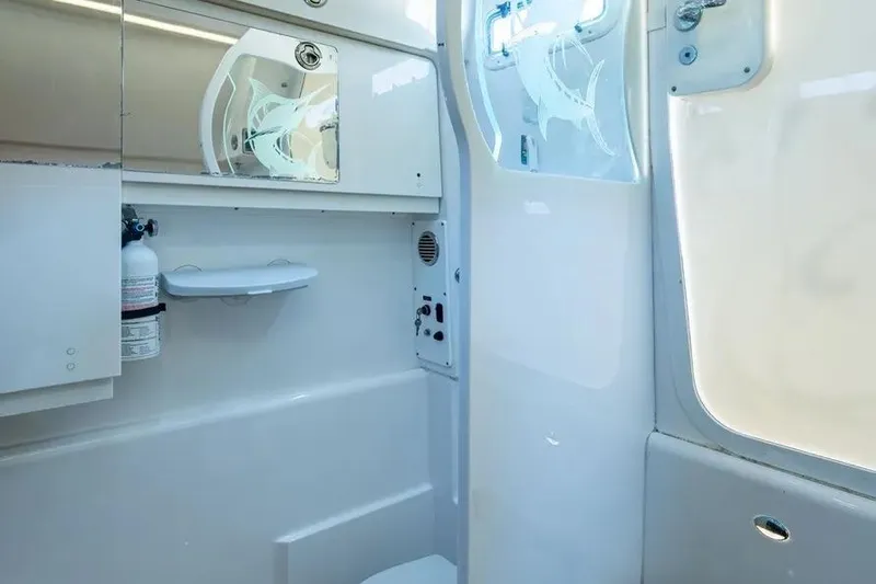 Slide: The Image of Interior of 2019 Everglades 435 Center Console boat, featuring a compact, modern bathroom. - 16