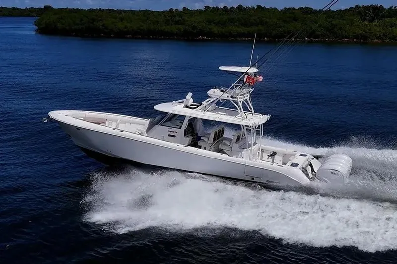 Slide: The Image of 2019 Everglades 435 Center Console boat cruising on a serene blue lake. - 8