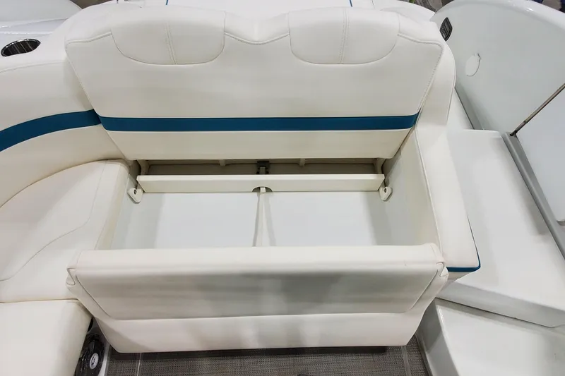 Slide: The Image of 2009 Formula 310 Bowrider boat seat with storage compartment, featuring white and blue upholstery. - 13