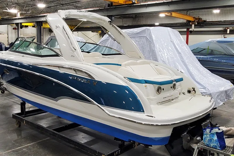Slide: The Image of 2009 Formula 310 Bowrider boat in a workshop, featuring sleek blue and white design. - 3