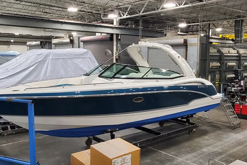 Slide: The Image of 2009 Formula 310 Bowrider boat in a workshop setting, blue and white exterior. - 4