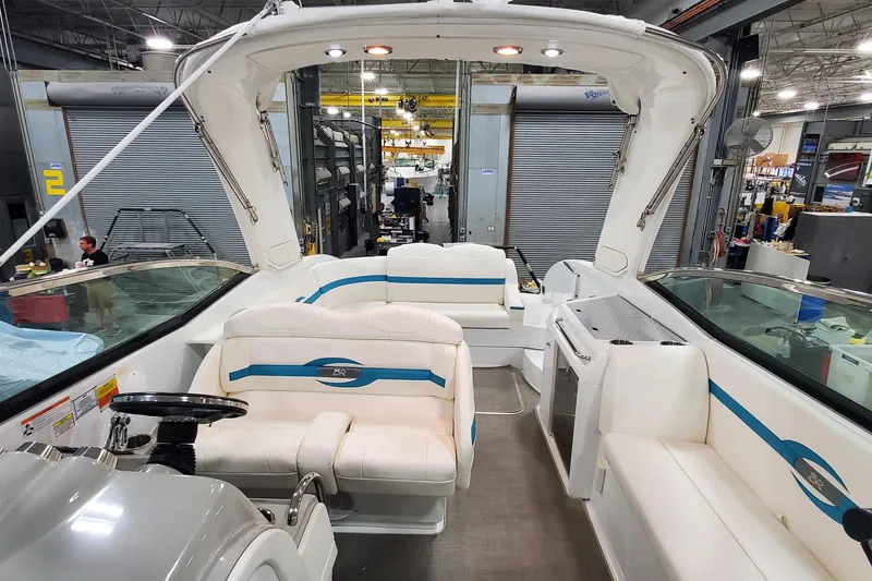 Slide: The Image of 2009 Formula 310 Bowrider interior with white seating and blue accents in a workshop setting. - 40