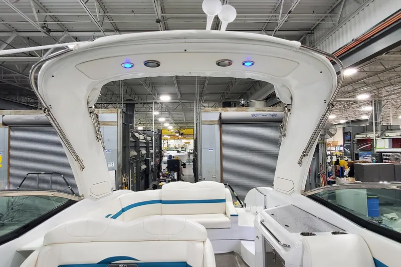 Slide: The Image of 2009 Formula 310 Bowrider interior with white seating and blue accents in a warehouse setting. - 45