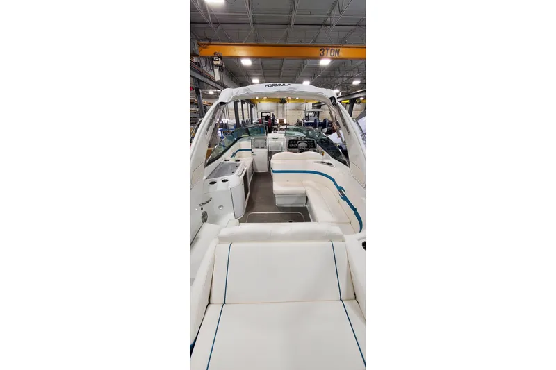 Slide: The Image of 2009 Formula 310 Bowrider interior with white seating in a warehouse setting. - 7