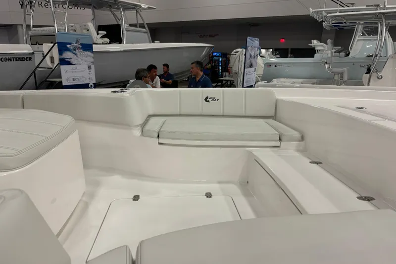 Slide: The Image of 2026 Contender 29 Bay boat interior at a showroom, featuring seating and sleek design. - 9