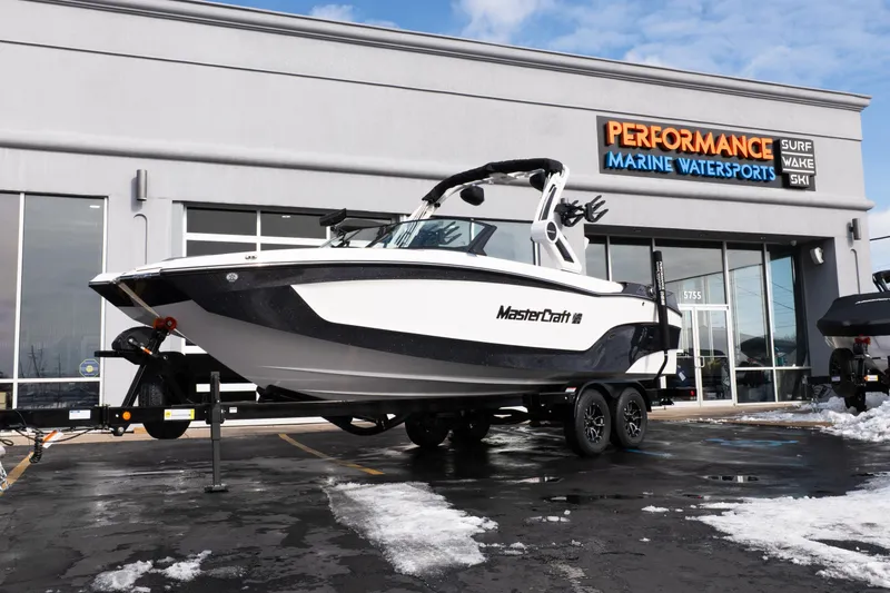 The Image of 2026 MasterCraft XT24 boat on trailer at Performance Marine Watersports dealership. - 0