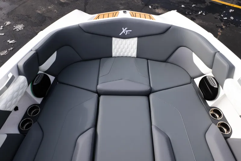 Slide: The Image of 2026 MasterCraft XT24 boat interior with gray seating and cup holders. - 19