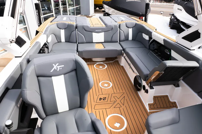 Slide: The Image of 2026 MasterCraft XT24 boat interior with luxurious gray seating and teak-style flooring. - 21