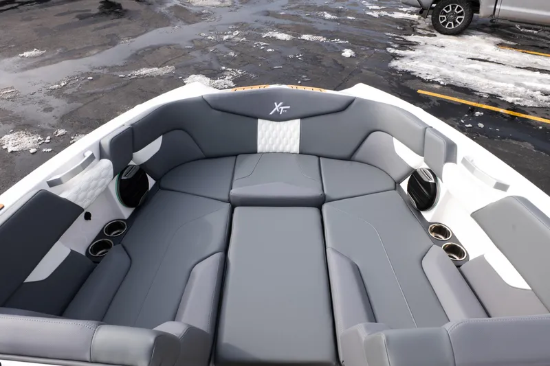 Slide: The Image of 2026 MasterCraft XT24 boat interior with gray seating and cup holders. - 23