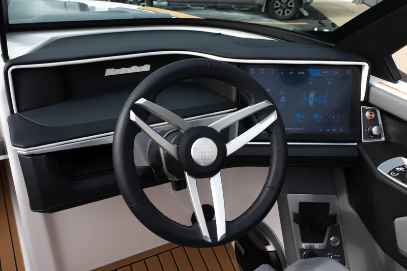Slide: The Image of 2026 MasterCraft XT24 boat dashboard with modern steering wheel and touchscreen display. - 24