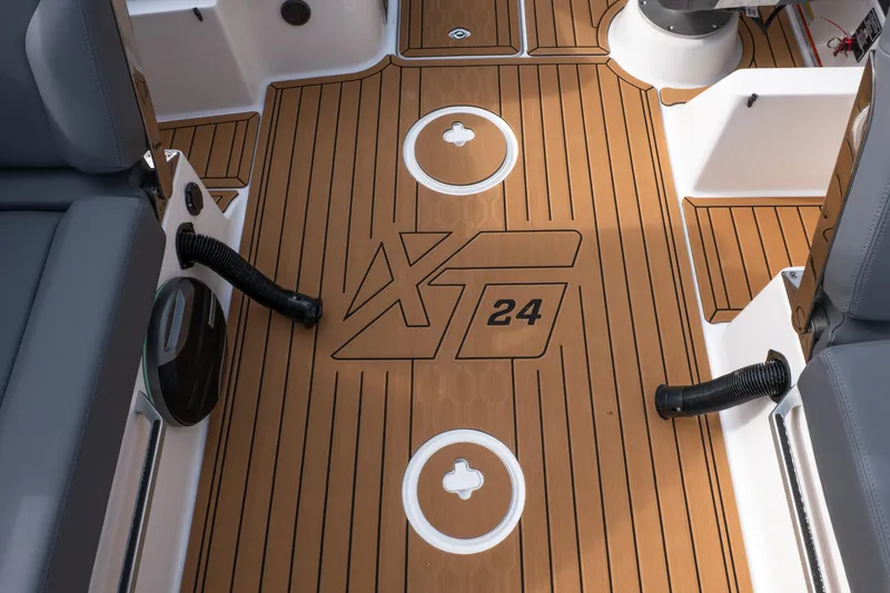 Slide: The Image of 2026 MasterCraft XT24 boat interior with teak-style flooring and seating. - 26